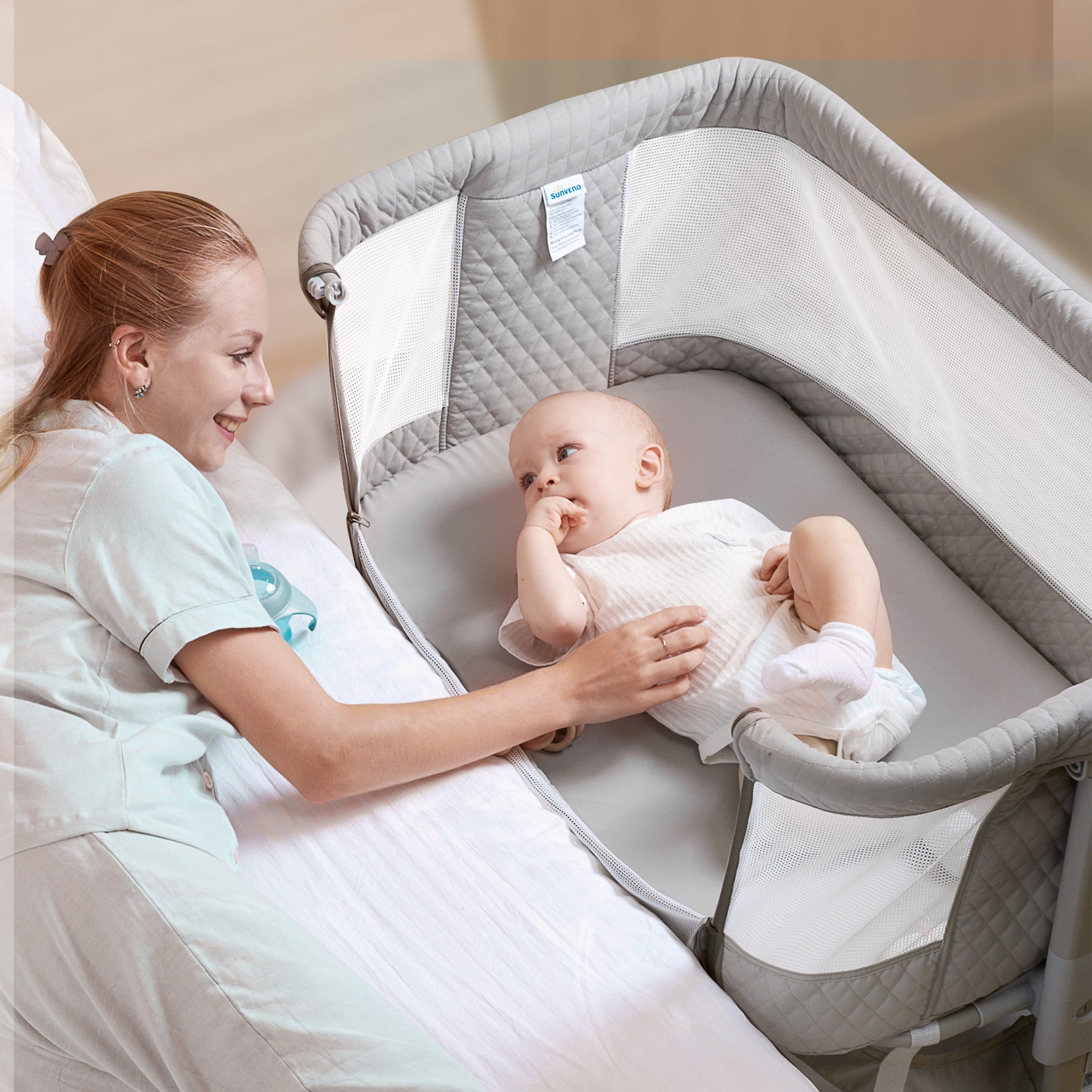 Mother with baby in a Baby Bassinet for bedside sleeping, promoting close bonding and nighttime care.