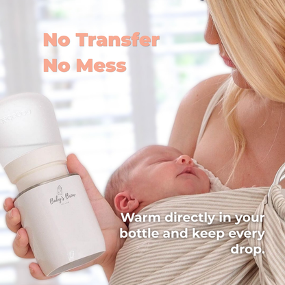 Mother holding her sleeping baby and a Baby's Brew portable bottle warmer attached to a baby bottle by Mama's Dream