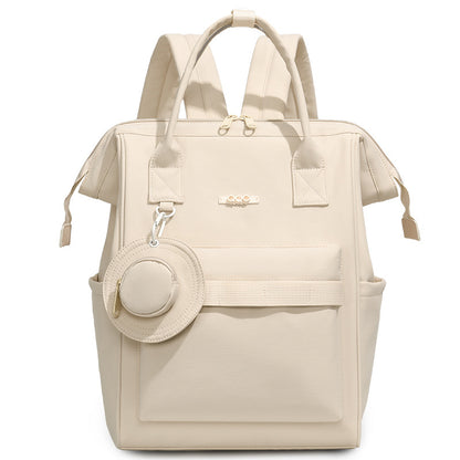 Beige convertible diaper bag backpack with top handles, side pockets and front storage compartment by Mama's Dream