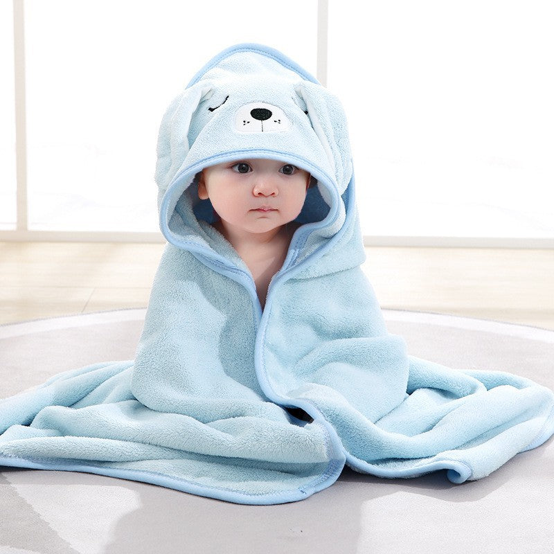 Baby wrapped in a soft blue hooded bath towel with an embroidered bear design by Mama's Dream