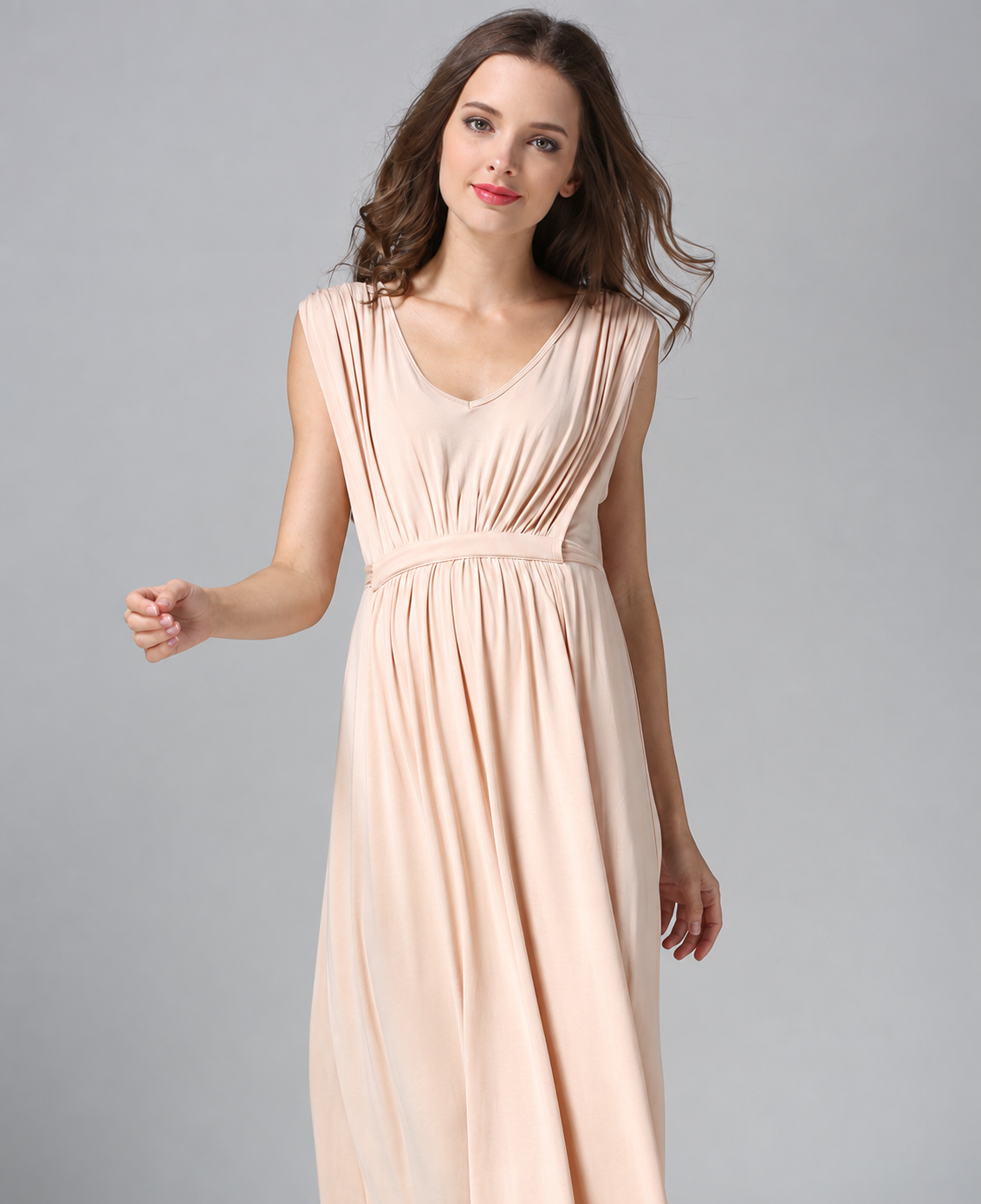 Pregnant woman wearing a blush pink sleeveless V-neck maternity maxi dress with a gathered empire waist by Mama's Dream