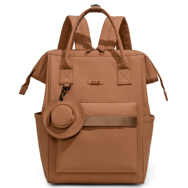Brown convertible diaper bag backpack with top handles, side pockets and front storage compartment by Mama's Dream