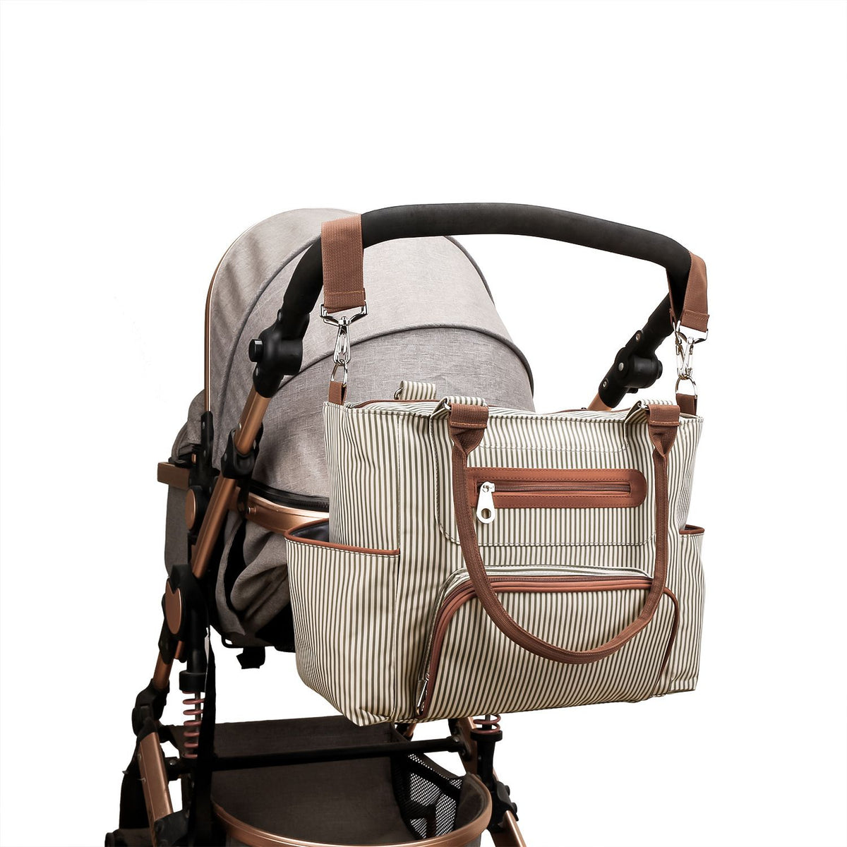 Striped diaper bag attached to a stroller with adjustable straps and exterior storage pockets by Mama's Dream