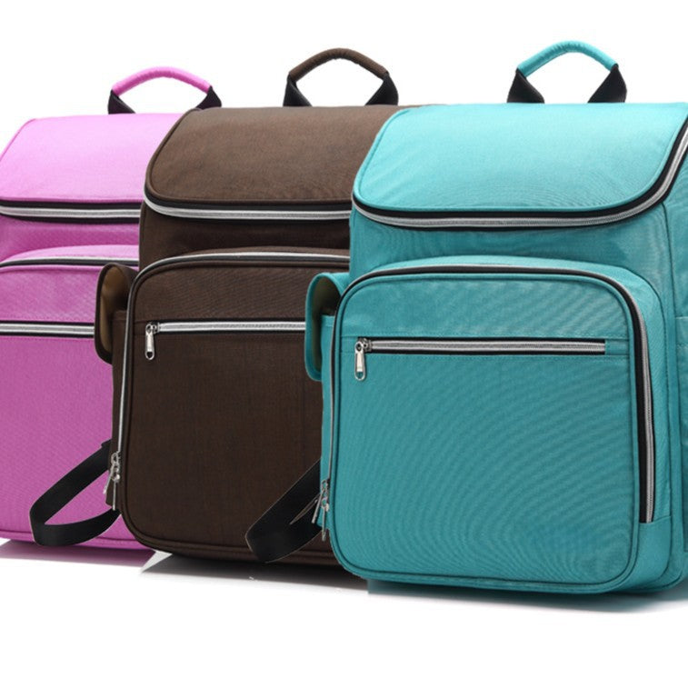 Diaper bag backpack color options in pink, brown and turquoise with multiple zippered compartments by Mama's Dream