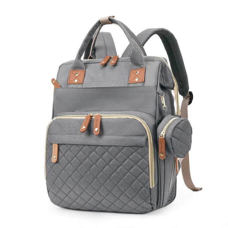 Gray quilted diaper bag backpack with top handles, padded shoulder straps and side accessory pouch by Mama's Dream
