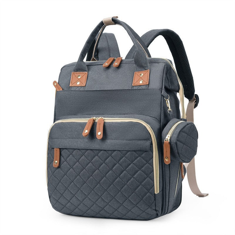 Gray quilted diaper bag backpack with top handles, padded shoulder straps and side accessory pouch by Mama's Dream