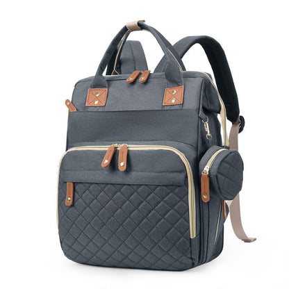 Gray quilted diaper bag backpack with top handles, padded shoulder straps and side accessory pouch by Mama's Dream