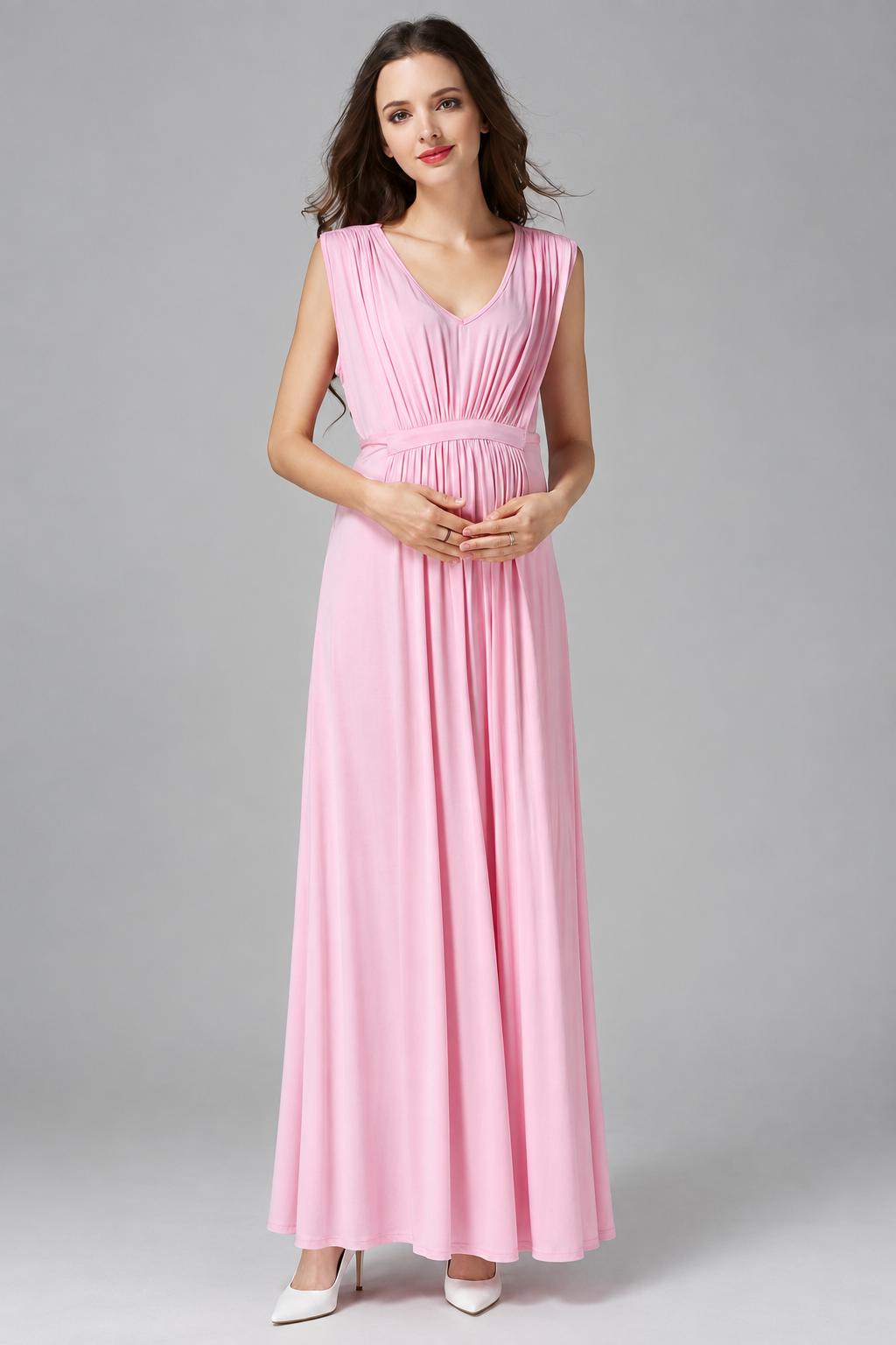 Pregnant woman wearing a light pink sleeveless V-neck maternity maxi dress with a gathered empire waist by Mama's Dream