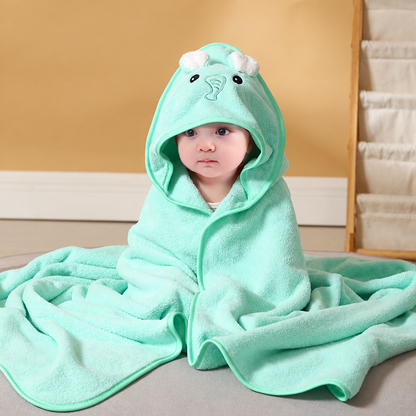 Baby wrapped in a soft mint green hooded bath towel with an embroidered elephant design by Mama's Dream