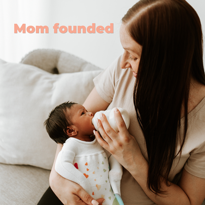 Mother feeding her newborn baby with a bottle while holding them in her arms by Mama's Dream