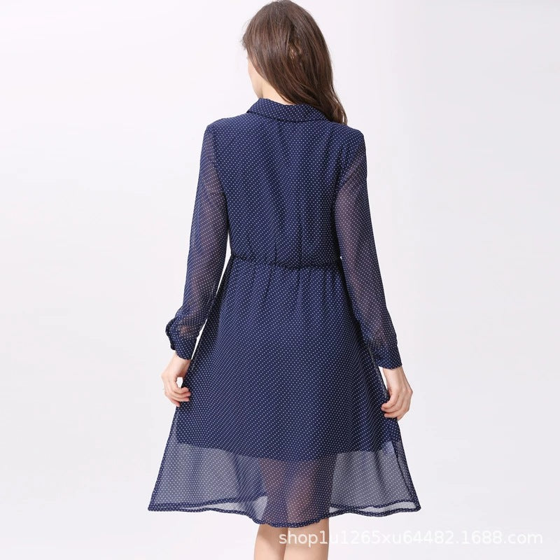 Back view of a navy polka dot maternity nursing dress with sheer long sleeves and a flowy hem by Mama's Dream