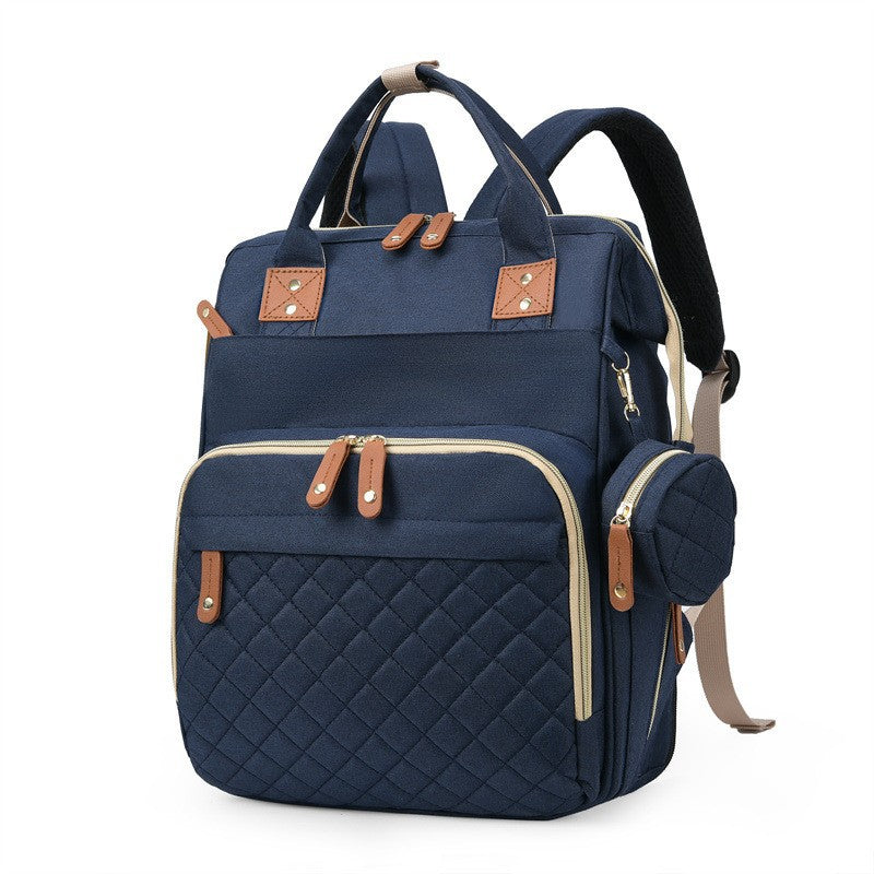 Navy blue quilted diaper bag backpack with top handles, padded shoulder straps and side accessory pouch by Mama's Dream