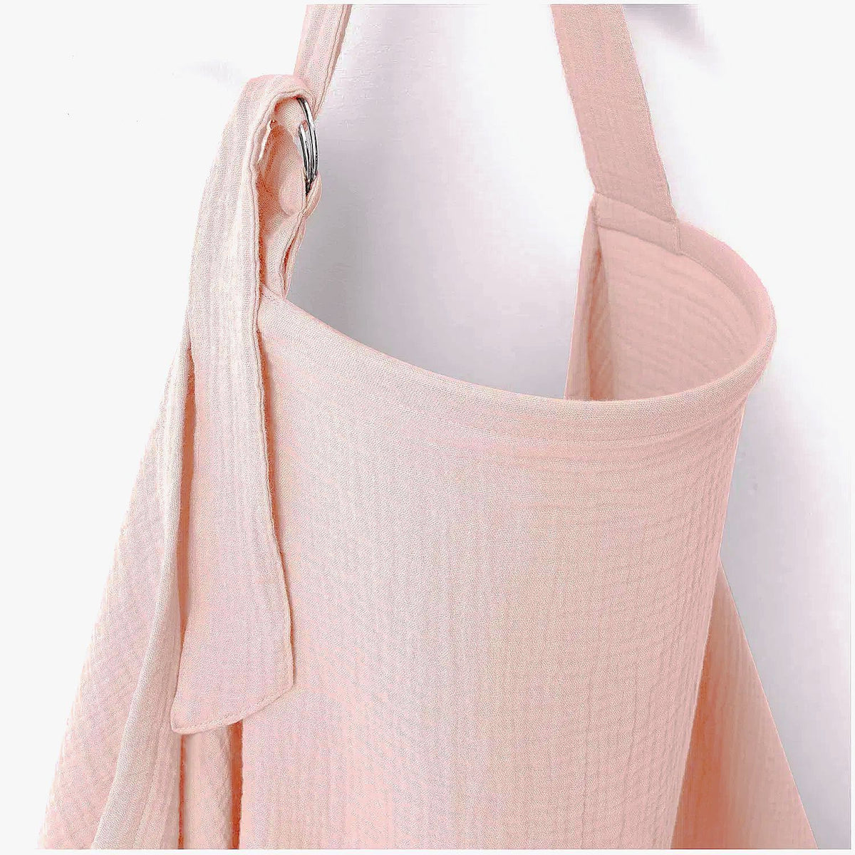 Soft pink nursing cover for breastfeeding with textured fabric and adjustable shoulder strap by Mama's Dream