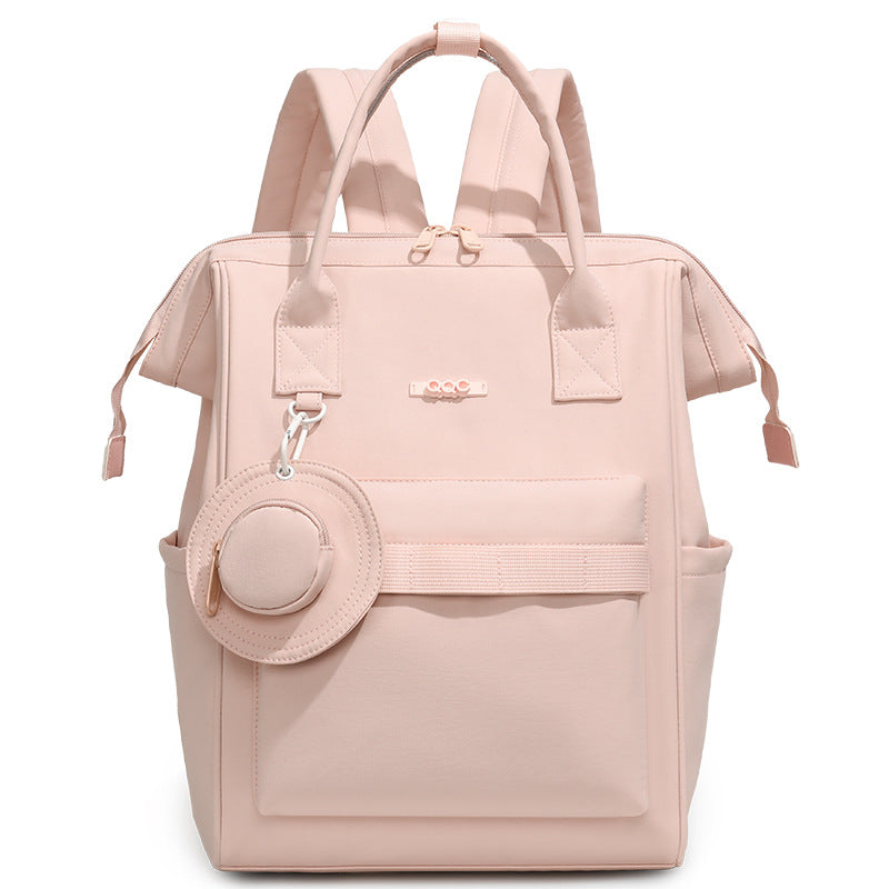 Blush pink convertible diaper bag backpack with top handles, side pockets and front storage compartment by Mama's Dream