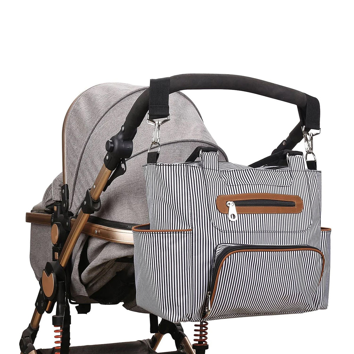 Striped diaper bag attached to a stroller with secure stroller straps and large exterior storage pockets by Mama's Dream